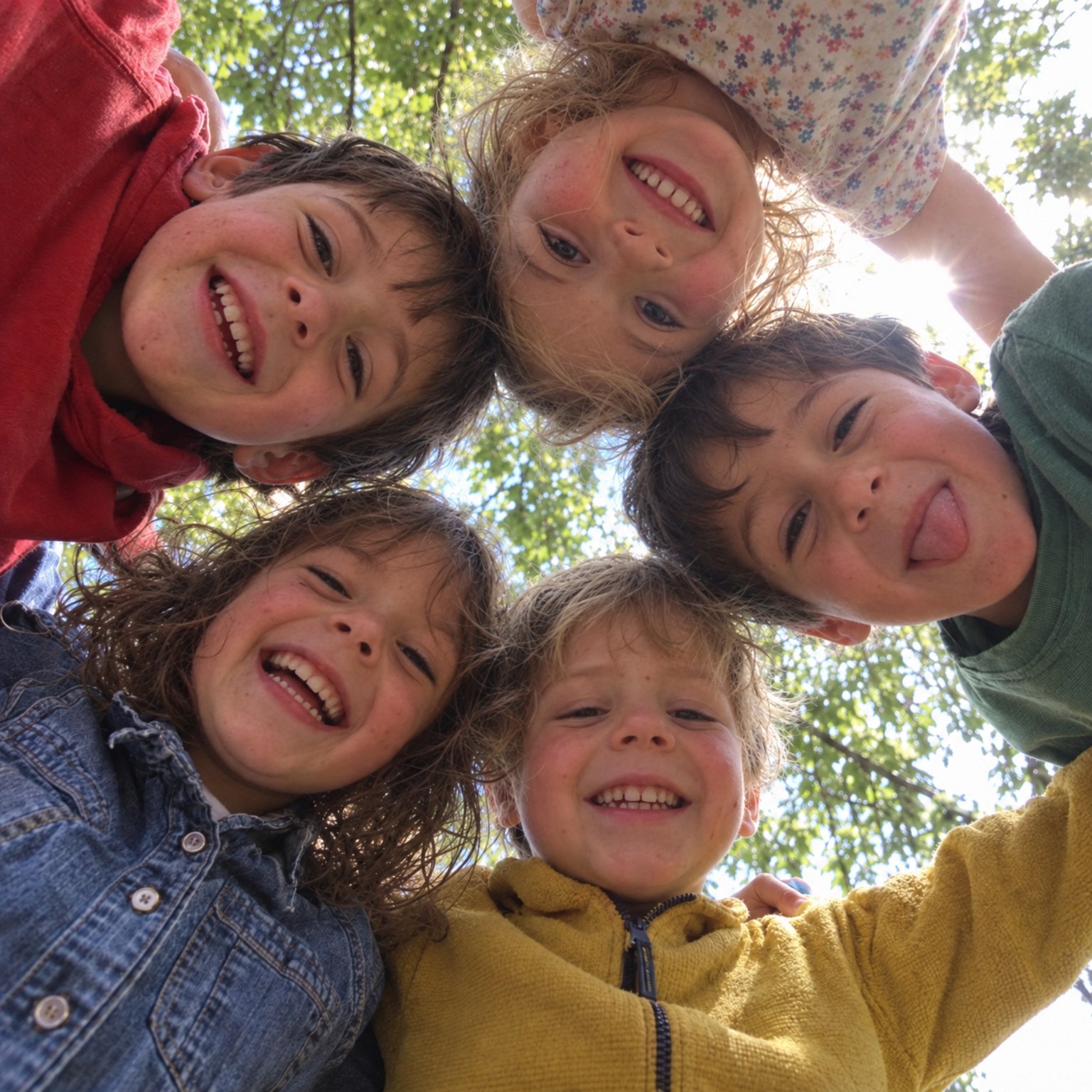 Bambini in cerchio che guardano l’obiettivo sorridendo